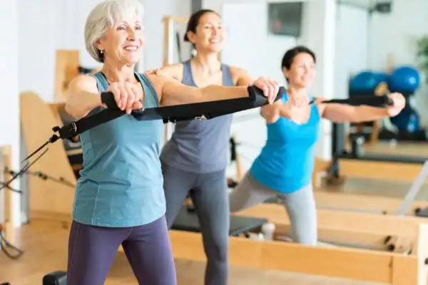 Toning Arms After 60: Empowering Womens Fitness Through Effective Weight Training 2 older woman doing weight training Scottish and resistance in the gym to tone upper arms