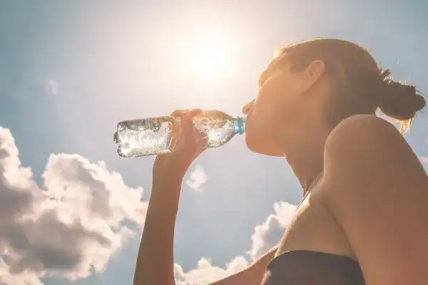 Hydration: The Secret Ingredient for a Toned Stomach and Enhanced Fitness 3 Image of woman drinking water to hydrate Scottish after run.
